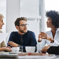 Give us difficult and well show you easy. Shot of a group of businesspeople sitting together in a meeting.